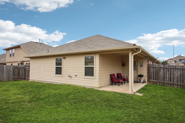 rear view of house featuring a lawn and a patio area