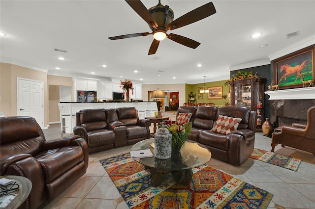 tiled living room featuring crown molding, a fireplace, and ceiling fan