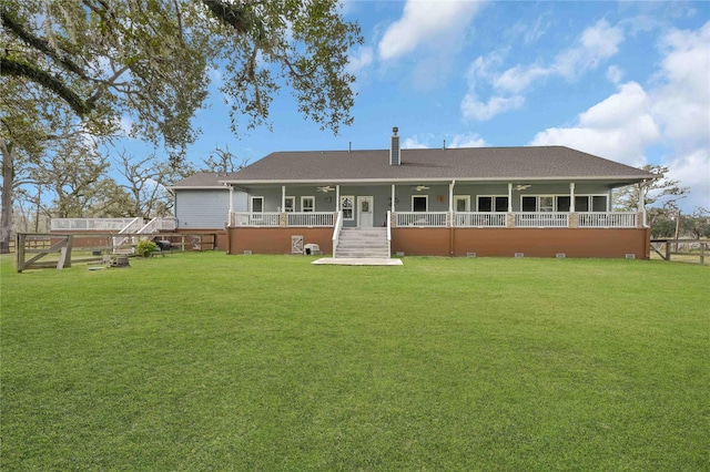 back of house featuring covered porch and a lawn