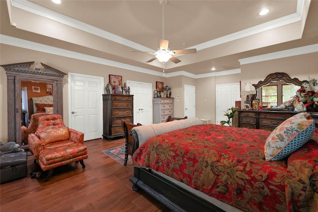 bedroom with ceiling fan, crown molding, dark hardwood / wood-style flooring, and a tray ceiling