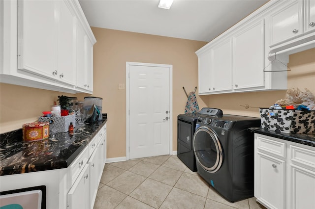 clothes washing area with cabinets, separate washer and dryer, and light tile patterned floors