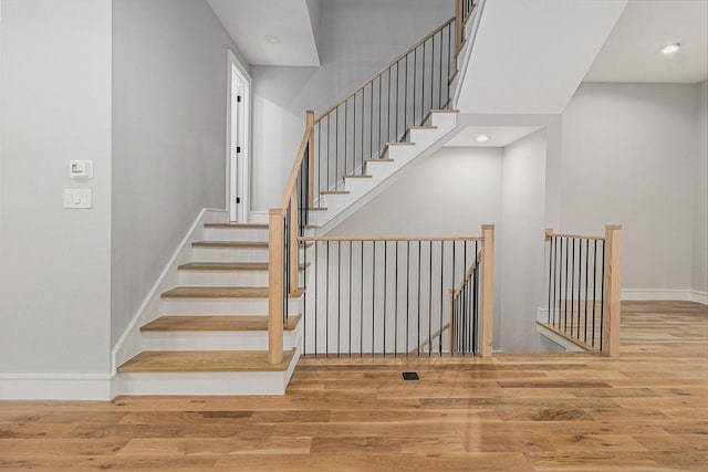 stairway with hardwood / wood-style floors