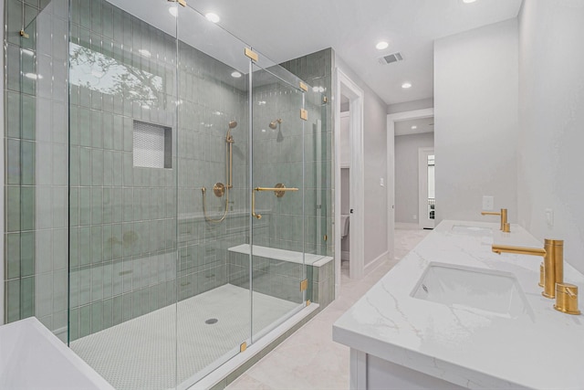 bathroom featuring tile patterned floors, a shower with shower door, and vanity