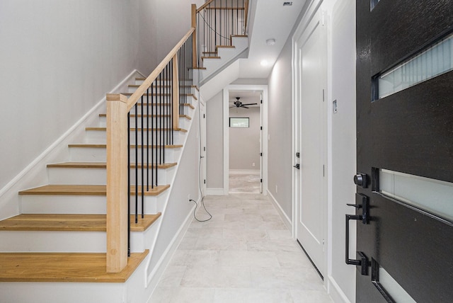 staircase featuring ceiling fan