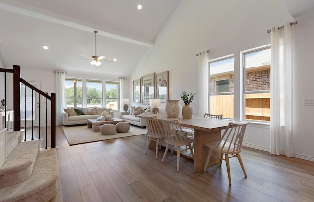 dining room with light hardwood / wood-style floors, high vaulted ceiling, and ceiling fan