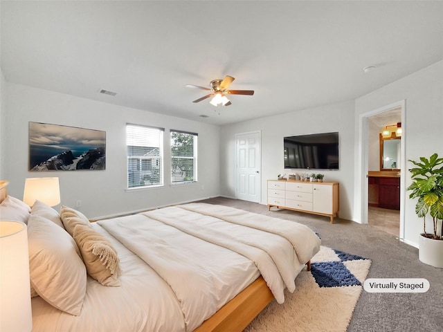 carpeted bedroom with ceiling fan and ensuite bath