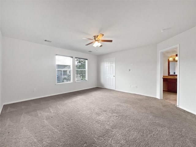 carpeted spare room featuring ceiling fan