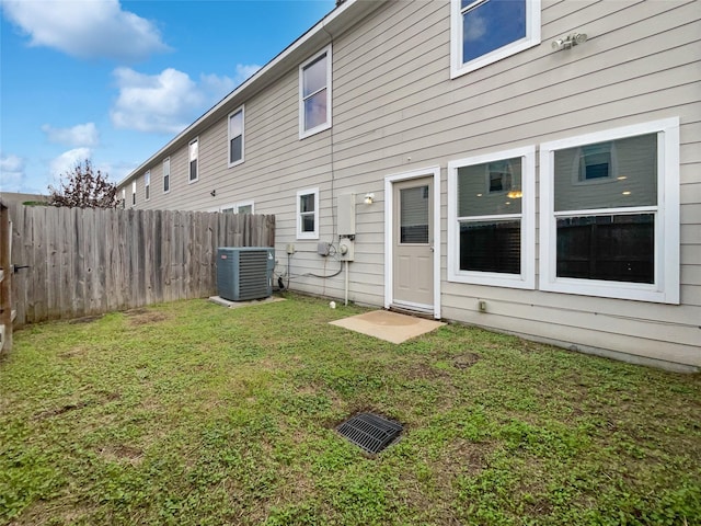 back of property with a lawn and central AC unit