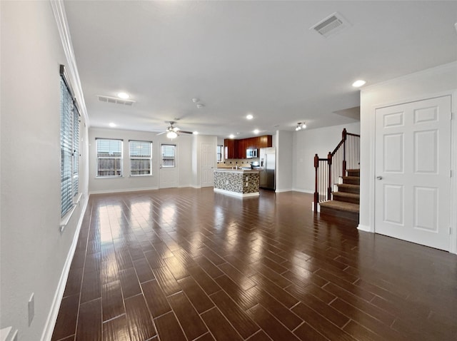 unfurnished living room featuring dark hardwood / wood-style flooring, ceiling fan, and crown molding