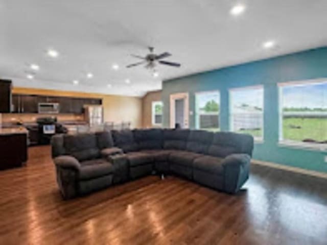 living room with dark hardwood / wood-style floors and ceiling fan