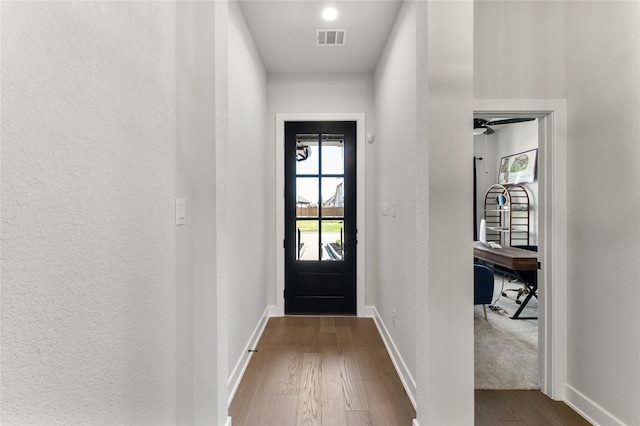 doorway featuring wood-type flooring and ceiling fan