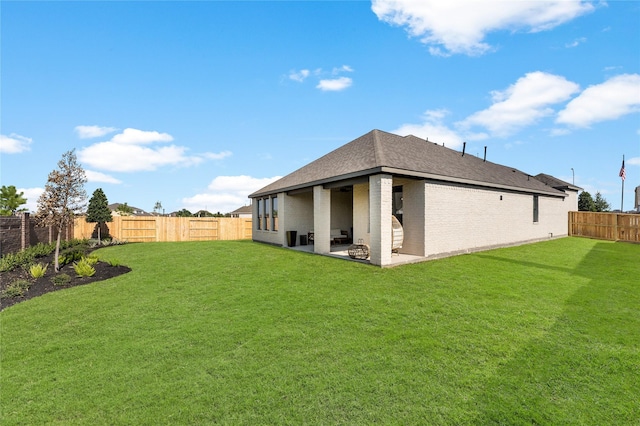 back of house featuring a lawn and a patio area