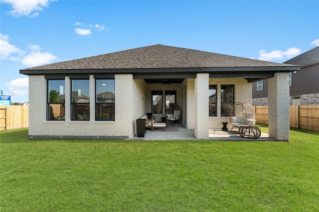 back of house featuring a lawn and a patio area