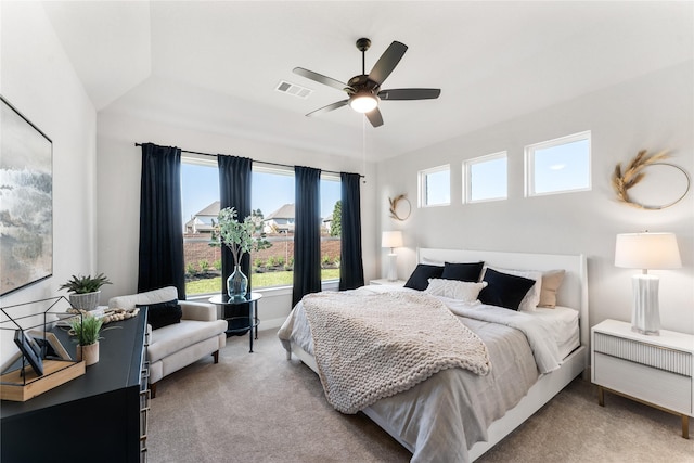 carpeted bedroom featuring ceiling fan and multiple windows