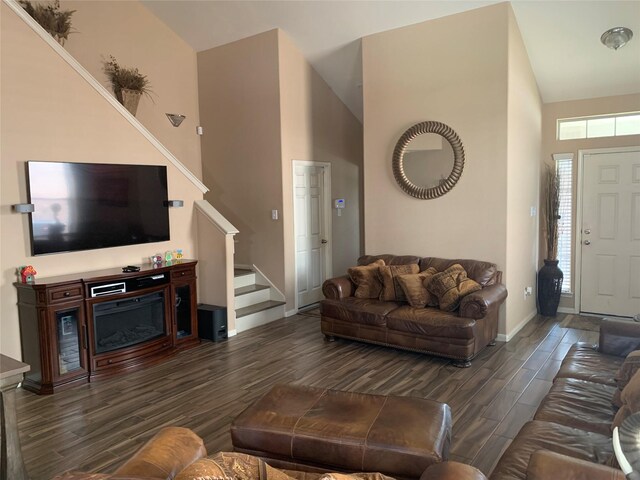 living room featuring high vaulted ceiling and dark wood-type flooring