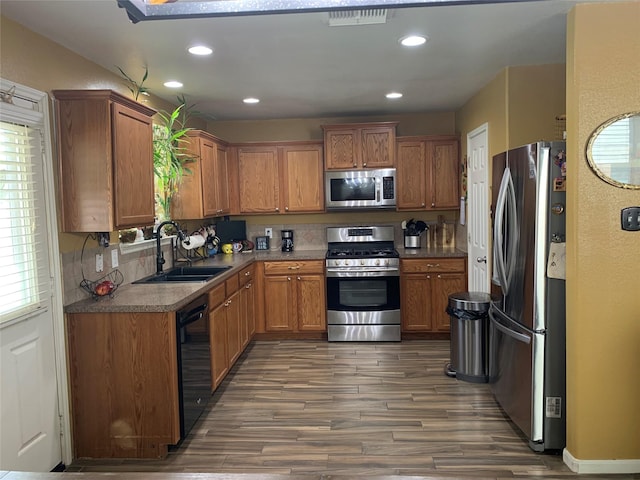 kitchen featuring decorative backsplash, appliances with stainless steel finishes, dark hardwood / wood-style flooring, and sink