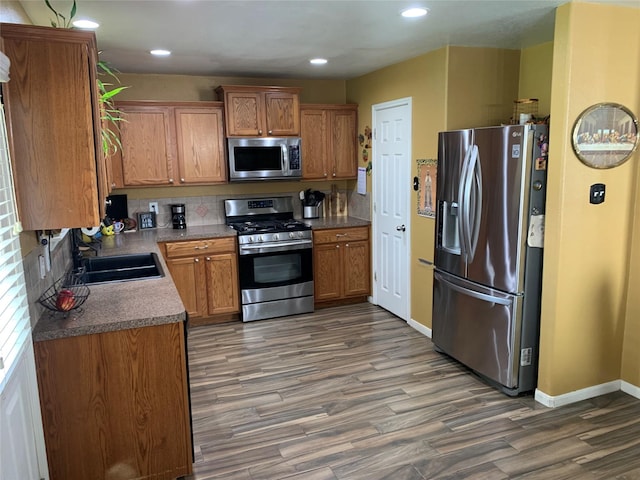 kitchen featuring dark hardwood / wood-style flooring, decorative backsplash, sink, and stainless steel appliances