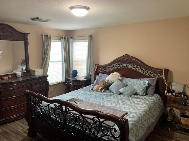 bedroom featuring a textured ceiling and dark wood-type flooring