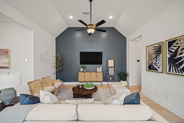 living room with ceiling fan, light hardwood / wood-style flooring, and vaulted ceiling