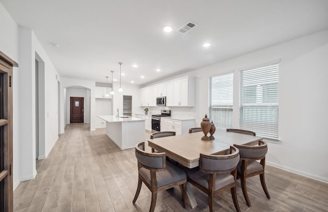 dining room featuring sink and light hardwood / wood-style flooring