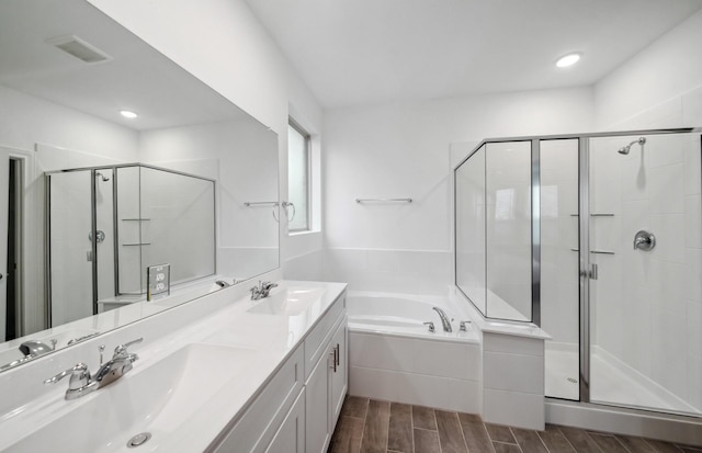 bathroom featuring vanity and independent shower and bath