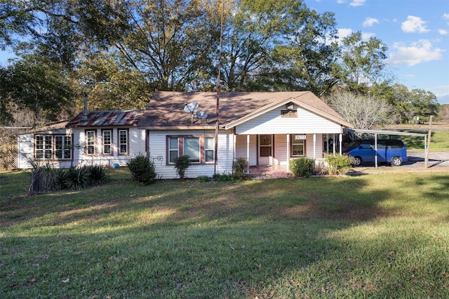 ranch-style home featuring a carport, covered porch, and a front lawn