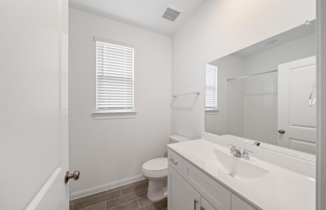 bathroom featuring vanity, toilet, and walk in shower