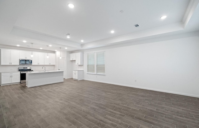 unfurnished living room with hardwood / wood-style flooring, sink, and a tray ceiling