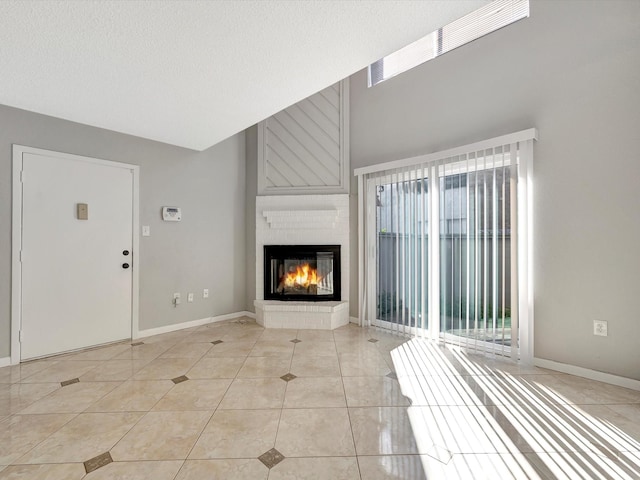 unfurnished living room featuring light tile patterned floors, a textured ceiling, and a brick fireplace