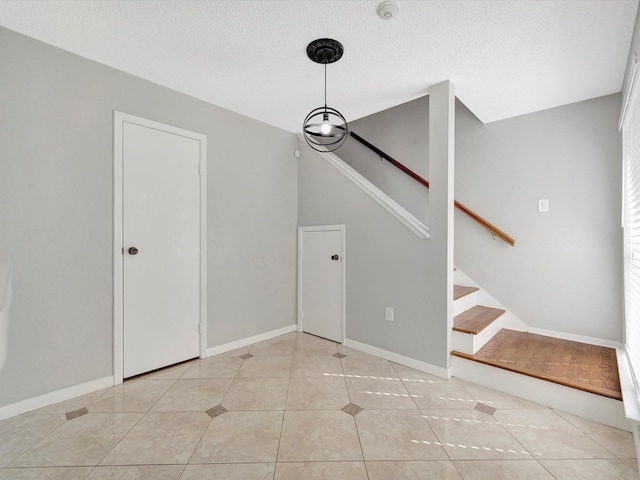 interior space featuring a wealth of natural light, light tile patterned floors, and a textured ceiling