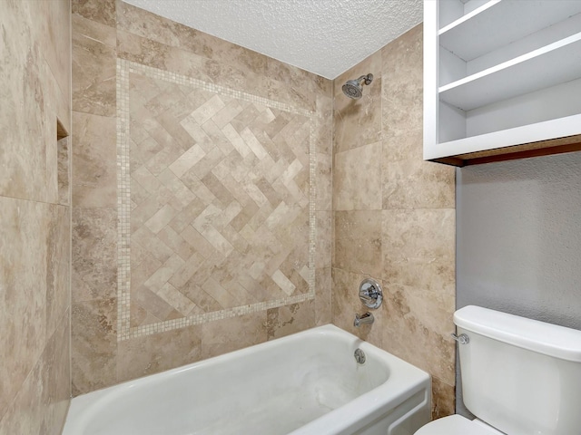 bathroom featuring tiled shower / bath, a textured ceiling, and toilet