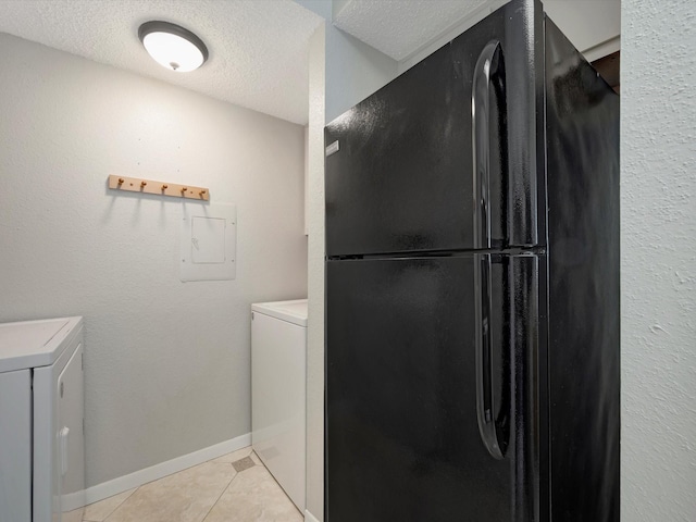 laundry area featuring washing machine and clothes dryer, a textured ceiling, electric panel, and light tile patterned flooring