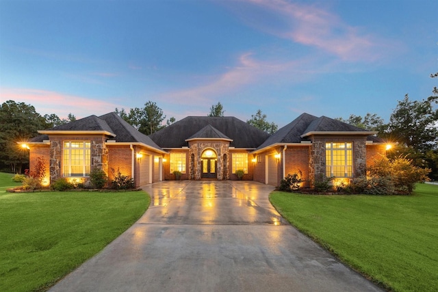 ranch-style house with a yard and a garage