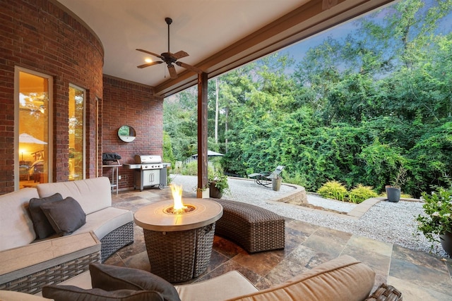 view of patio with ceiling fan, a grill, and an outdoor living space with a fire pit