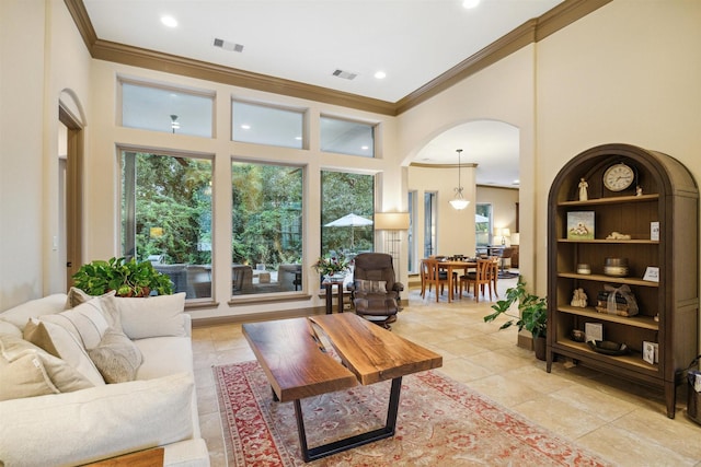 living room featuring light tile patterned flooring, a towering ceiling, and crown molding