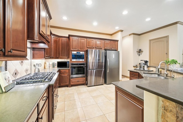 kitchen featuring kitchen peninsula, appliances with stainless steel finishes, crown molding, sink, and light tile patterned floors