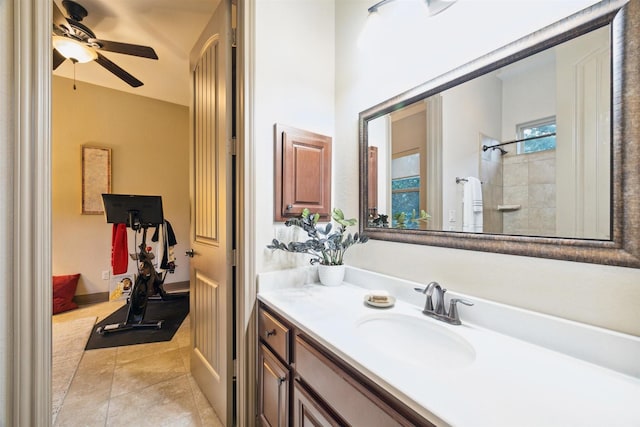 bathroom featuring tiled shower, vanity, tile patterned flooring, and ceiling fan