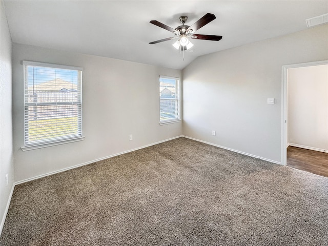 carpeted spare room with ceiling fan, lofted ceiling, and a wealth of natural light