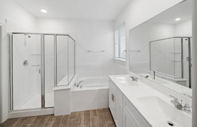 bathroom featuring a garden tub, a stall shower, a sink, and wood finish floors