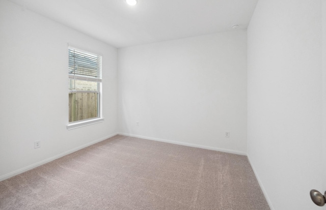 carpeted empty room with baseboards