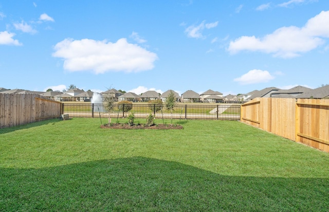 view of yard with a fenced backyard and a residential view