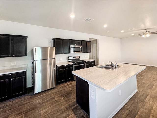 kitchen featuring dark hardwood / wood-style flooring, sink, an island with sink, and appliances with stainless steel finishes