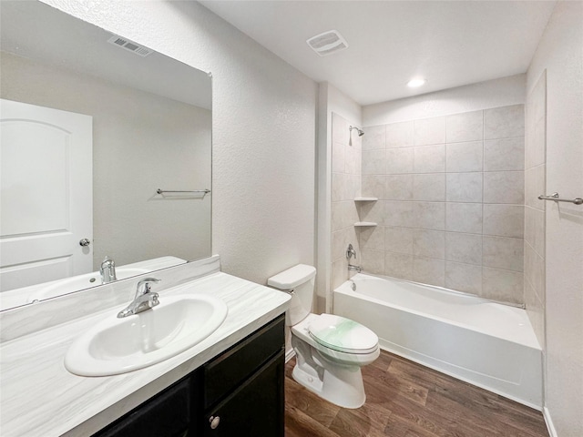 full bathroom featuring wood-type flooring, vanity, toilet, and tiled shower / bath