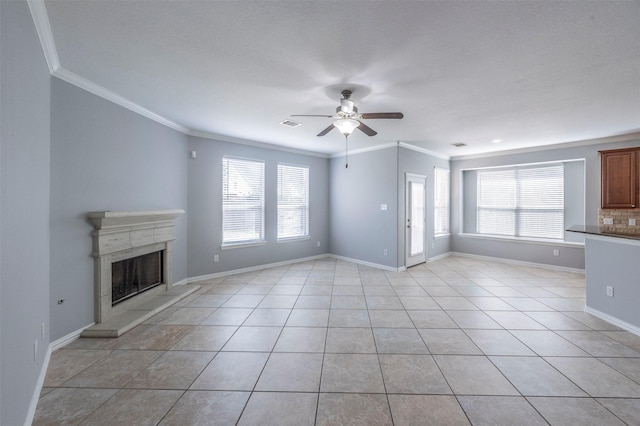 unfurnished living room with a wealth of natural light, ceiling fan, and ornamental molding