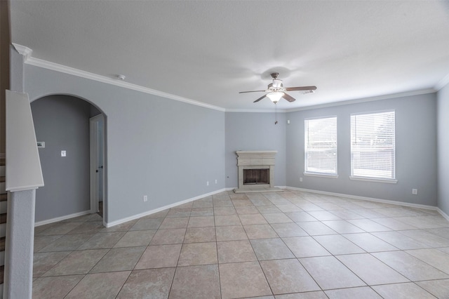 unfurnished living room with ceiling fan, crown molding, and light tile patterned floors