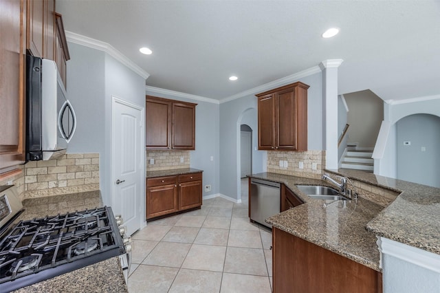 kitchen featuring backsplash, stainless steel appliances, dark stone countertops, and sink