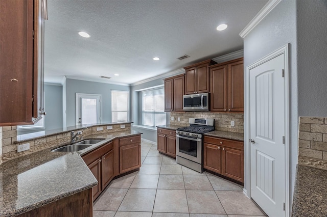 kitchen with sink, stainless steel appliances, backsplash, crown molding, and light tile patterned floors