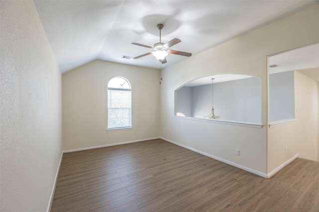 spare room with ceiling fan, lofted ceiling, and dark wood-type flooring