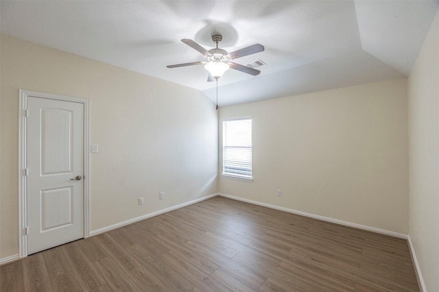 spare room featuring wood-type flooring, vaulted ceiling, and ceiling fan