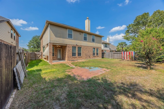 rear view of house with a patio and a lawn